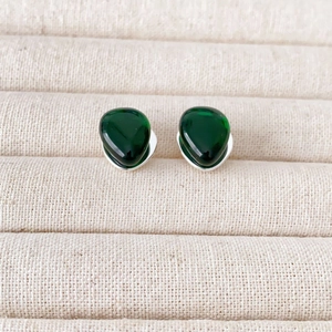 Minimalist 925 silver stud earrings with teardrop green glass on beige velvet
