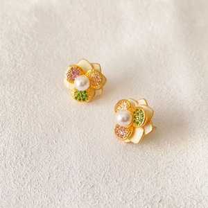 Elegant gold flower earrings with white enamel petals, colorful crystals, and faux pearls