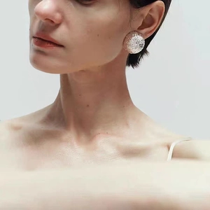 Retro hollow hemispherical earrings with brushed texture on model in silver finish