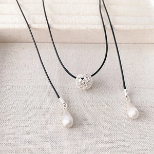 Minimalist brushed silver sphere pendant necklace with black cord and pink crystals