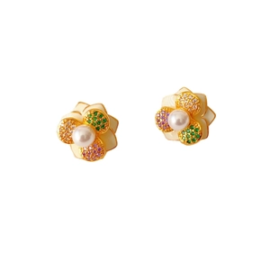 Elegant gold flower earrings with central pearl and colorful gemstones on white background