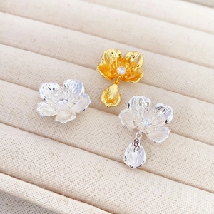 Vintage asymmetric 3D flower stud earrings with diamonds on a beige velvet holder