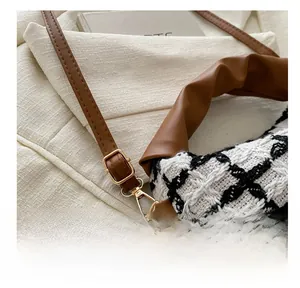 Détail de la quincaillerie dorée et de la bandoulière en cuir sur sac en tweed à carreaux
