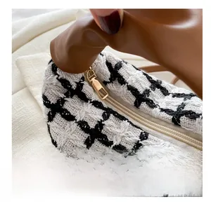Gros plan détaillé de la fermeture éclair en métal doré sur un sac à main en tweed chic