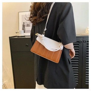 Close-up of contrast color crossbody bag with knot handle and pleated texture details