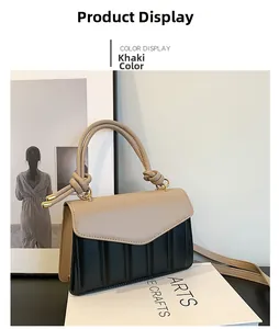 Detail of khaki and black contrast flap handbag with quilted texture and knot handle