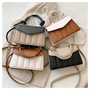 Detail of color-block quilted handbags with knotted handles and gold metal hardware
