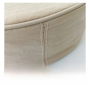 Detailed close-up of double-stitched seams on beige textile fabric shoulder bag