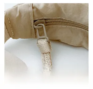 Detail view of the smooth zipper and durable nylon fabric on the beige dumpling bag