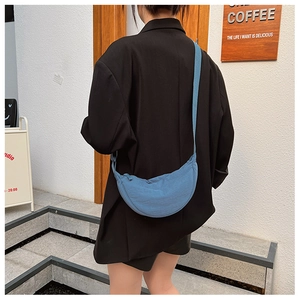 Detail view of the blue crescent crossbody bag featuring durable nylon fabric and strap