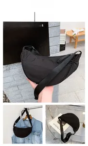 Detail of black nylon crescent bag featuring adjustable strap and sleek top zipper closure