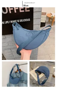 Detail of blue nylon crescent moon bag featuring a durable zipper and wide adjustable strap