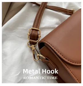 Close-up of golden hardware hook and adjustable brown PU leather strap for crossbody bag