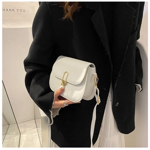 Detail of white PU leather crossbody bag featuring a designer gold U-shaped metal buckle