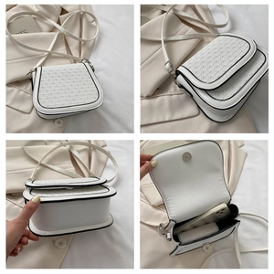 Detail view of white woven saddle bag with black trim from multiple perspective angles