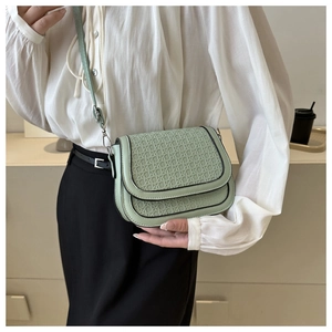 Detail of woven texture on mint green saddle bag with adjustable shoulder strap