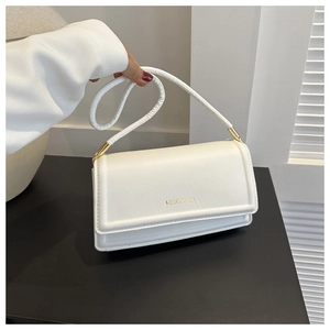 Detailopname van witte kunstlederen mini handtas met gouden hardware en logo