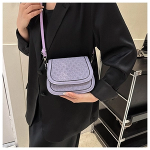 Detail of purple woven texture on a minimalist small flap crossbody bag with silver hardware