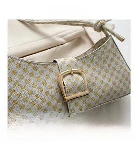Détail du motif trèfle jaune sur un sac baguette rétro avec boucle dorée