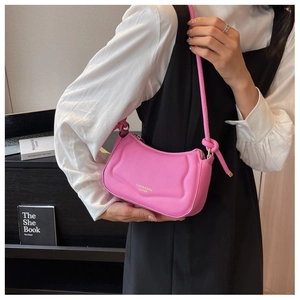 Detail der rosa Leder-Schultertasche mit gewellter Prägung und goldenem Logo