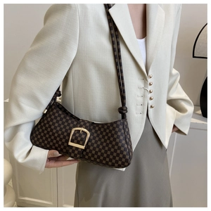 Détail du sac baguette vintage avec boucle dorée sur l'épaule du mannequin femme