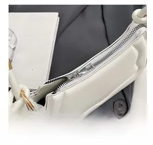 Detail des glatten silbernen Metallreißverschlusses am weißen Satteltaschen-Leder