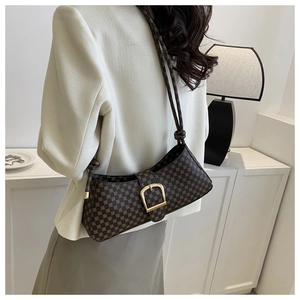 Vue latérale d'un sac baguette vintage marron à motifs avec grande boucle dorée