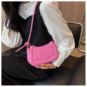 Nahaufnahme der pinkfarbenen Ledersatteltasche mit Wellenstruktur und Knoten
