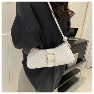 Vue latérale d'un sac sous le bras vintage blanc à carreaux avec boucles dorées