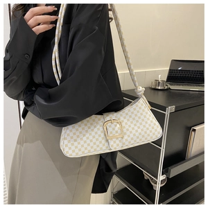 Vue détaillée du sac baguette à carreaux avec grande boucle dorée sur l'épaule