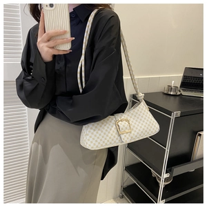 Sac à bandoulière beige chic avec boucle dorée et motif géométrique porté par mannequin