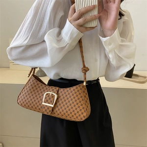 Détail du sac baguette vintage marron avec boucle dorée et motif texturé élégant