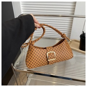 Gros plan détaillé d'un sac baguette marron vintage avec monogramme et boucle dorée