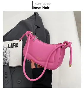 Detail der rose-pinkfarbenen Satteltasche mit knotigem Griff und glatter Lederstruktur