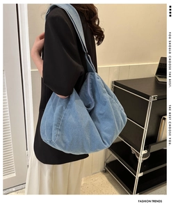 Sac hobo en jean bleu porté en bandoulière sur modèle pour un usage quotidien décontracté