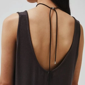 Minimalist dark grey backless knit vest featuring a deep V-back and silver metal pendant