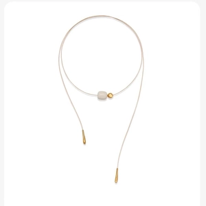 Minimalist Y-necklace with ivory-colored geometric bead and golden teardrop charms