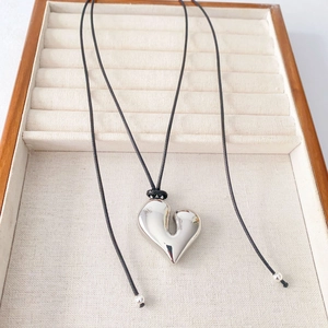 Minimalist silver heart pendant necklace with polished mirror finish and black cord