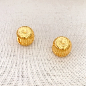 French vintage style round gold plated earrings with firework texture on white fabric