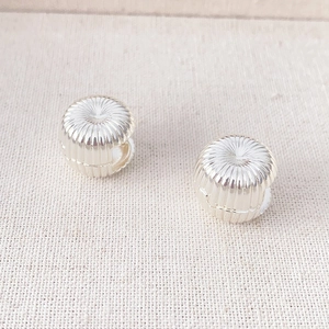 French vintage silver hoop earrings with radial texture on a linen background