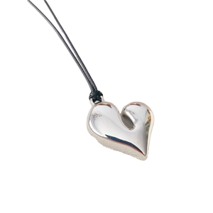 Minimalist silver heart pendant necklace with black cord cord on a clean white background
