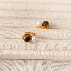 Elegant gold-plated earrings featuring tiger eye and white pearl on velvet
