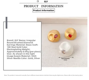 Detailed view of brushed brass earrings with 18K gold plating and red zircon stone