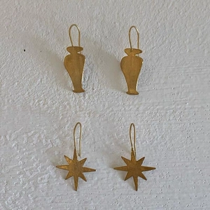 Détails de boucles d'oreilles dorées en forme de vase et d'étoile avec fini mat