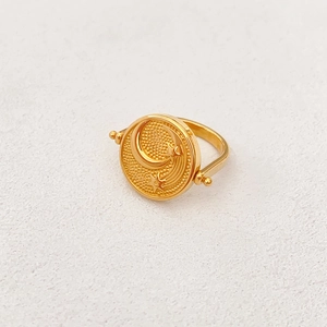 Anello rotante dorato con rilievo di sole luna e stelle su superficie testurizzata