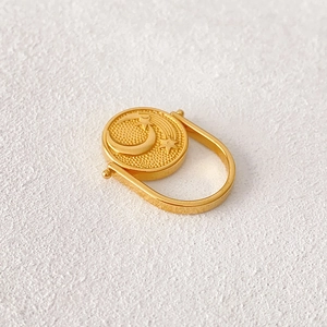 Anello rotante dorato con motivi in rilievo di sole luna e stelle dallo stile vintage