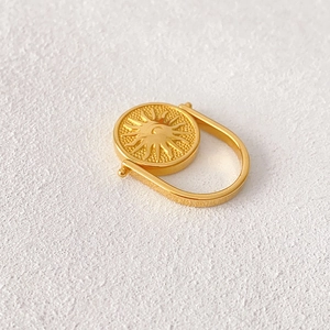 Anello girevole dorato vintage con rilievo sole e luna su struttura in pietra
