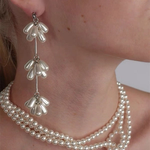 Vue macro de boucles d'oreilles pendantes en perles et d'un collier de perles multicouche