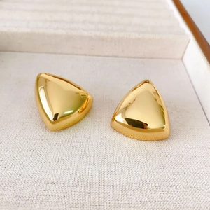 Detailed close-up of geometric gold-plated triangle earrings with high-polish finish