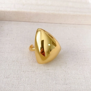 Macro shot of gold-plated triangle stud earring with polished surface and 925 silver pin